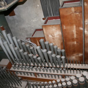 Starke Verschmutzung des Pfeifenwerks; im Hintergrund der Untersatz 32' aus Holz an der Orgelrückwand